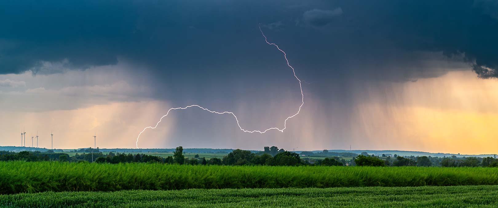 Gewitter über einem Feld mit lautem Blitzeinschlag
