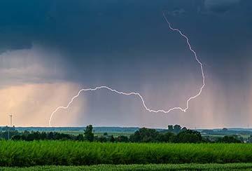 Gewitter über einem Feld mit lautem Blitzeinschlag